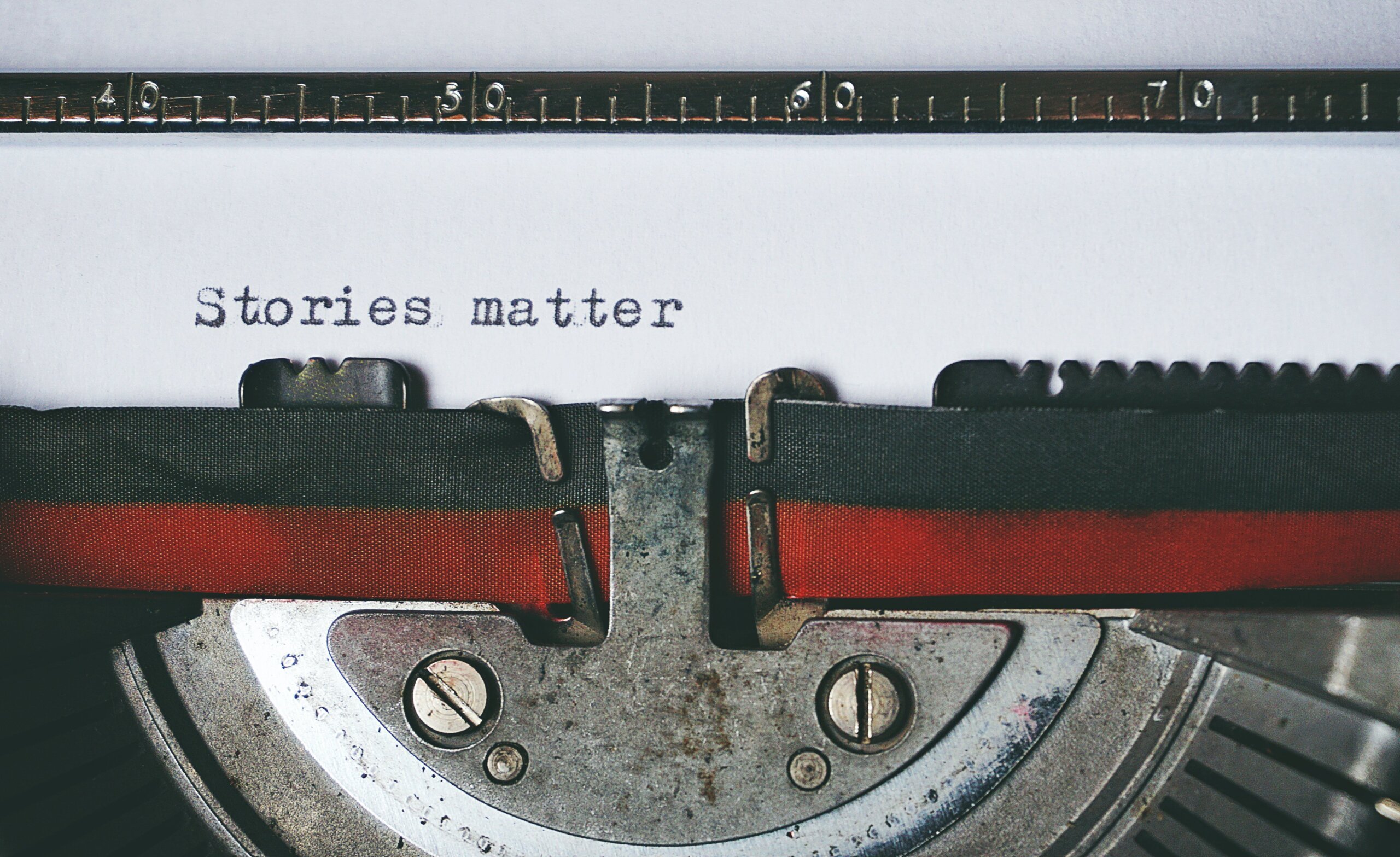 Typewriter with black paper with the words "Stories matter"